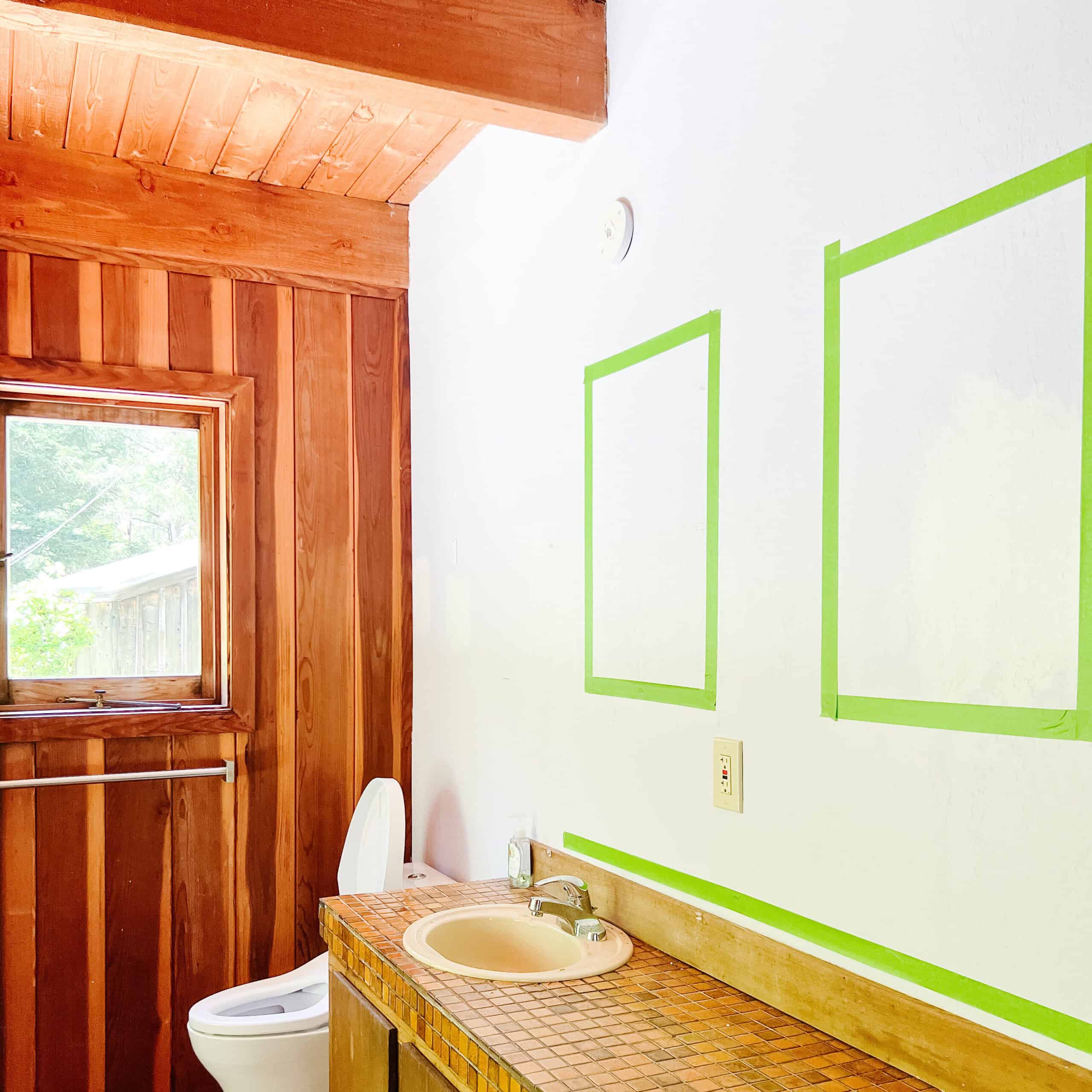 Unfinished bathroom with green tape marking the walls.