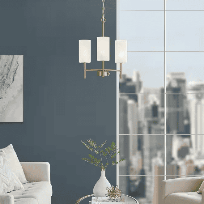 Brass chandelier hanging in a room with blue walls.