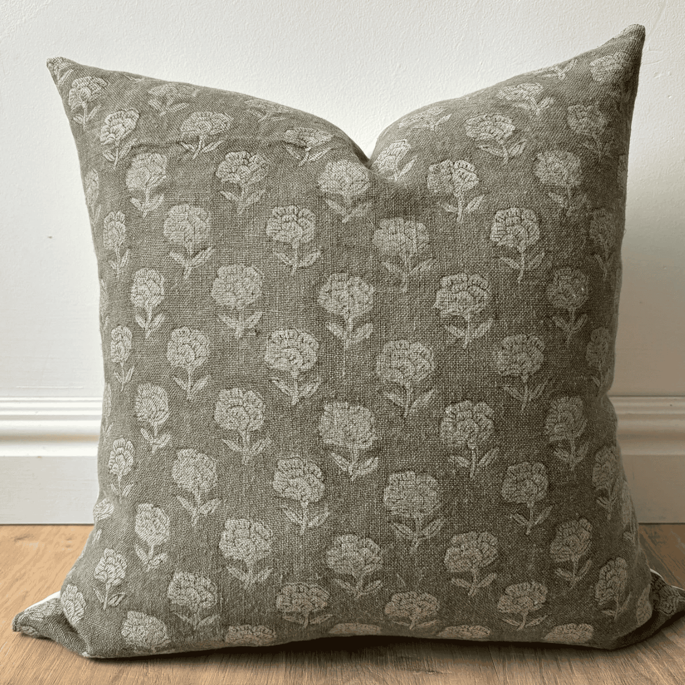 Green throw pillow with a floral print.
