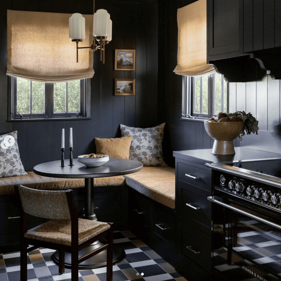 Dark corner of a kitchen with throw pillows and candlesticks.