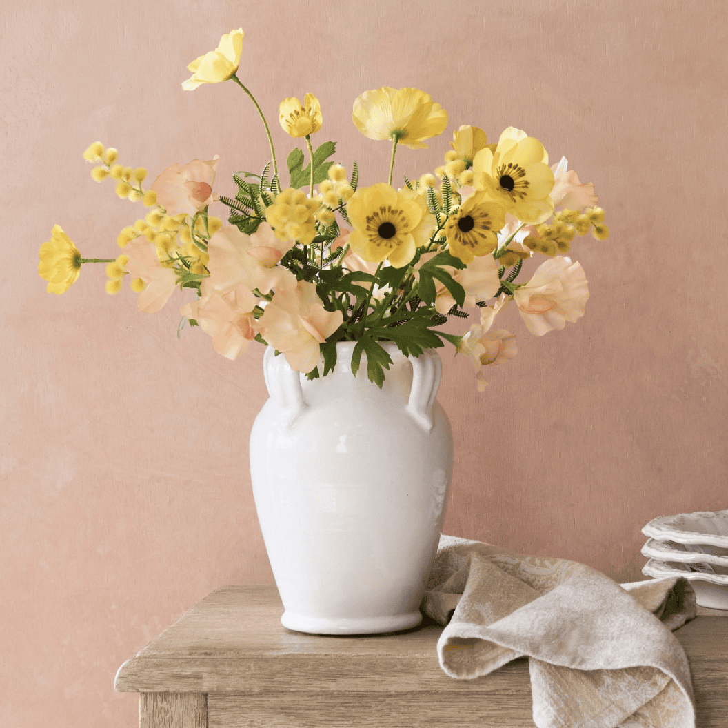 faux flowers in a white vase 