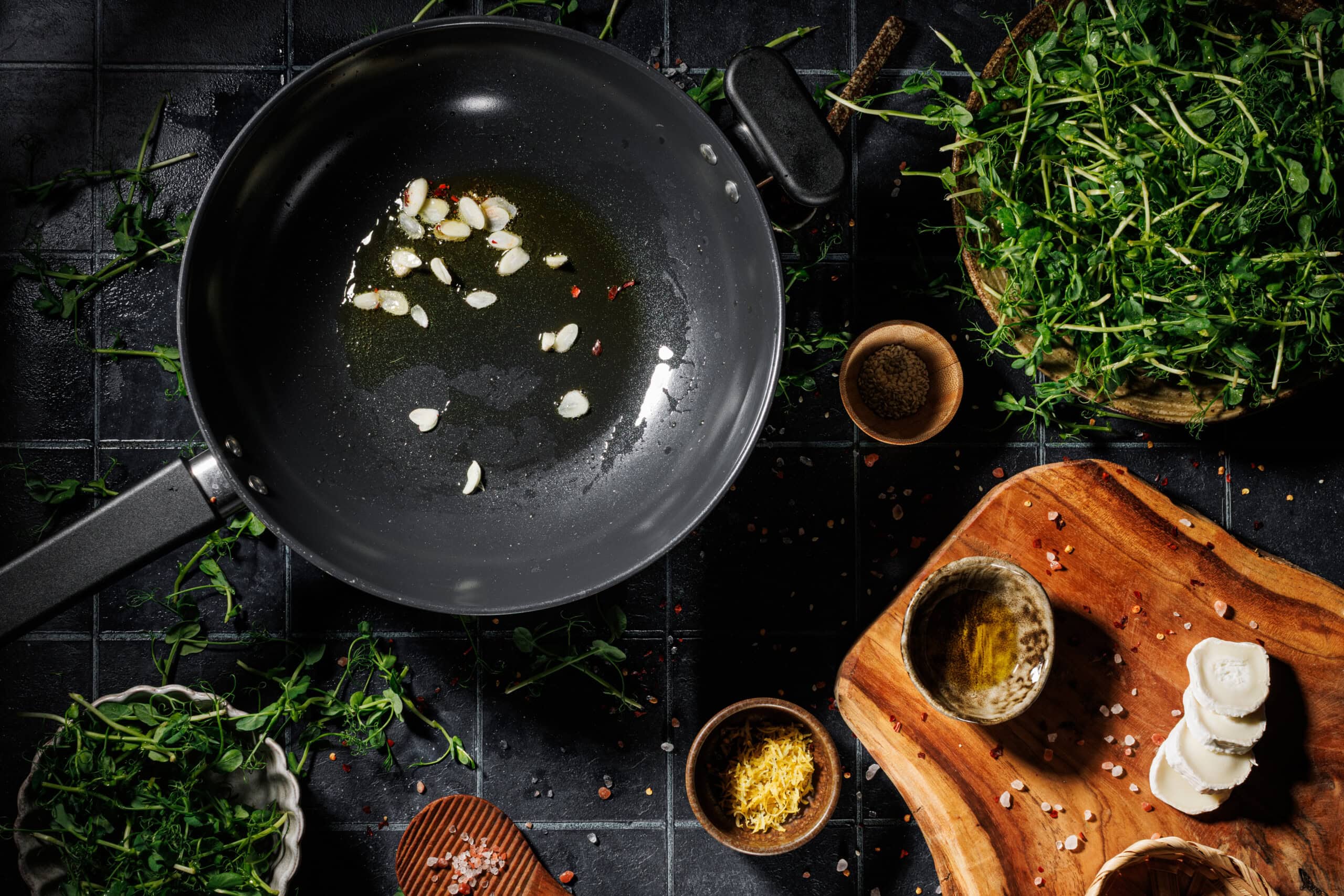 Avocado oil and sliced garlic cooking in a skillet until golden and crispy.