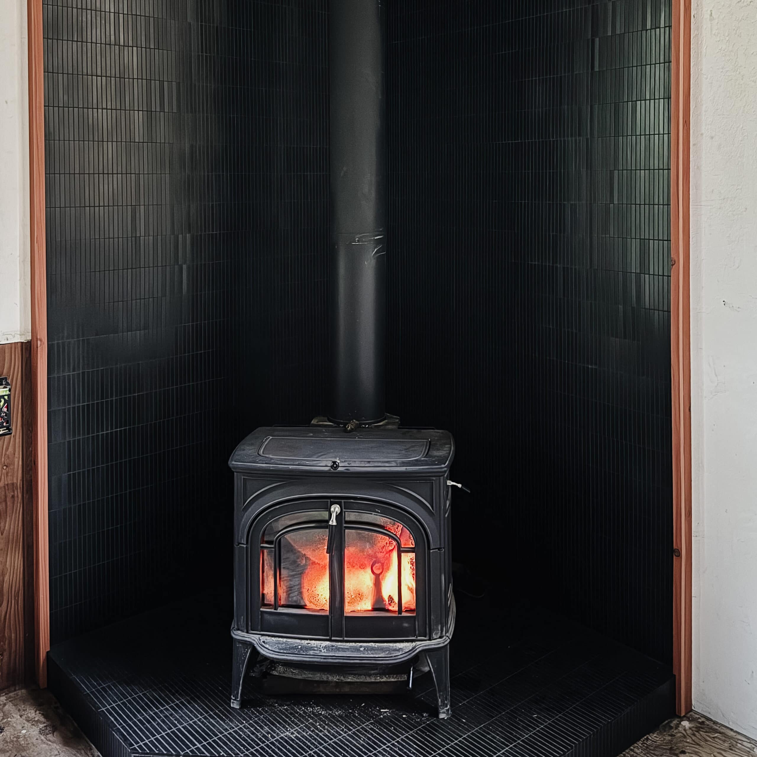 The dauntless vermont castings wood stove in my cabin remodel on black tile. 