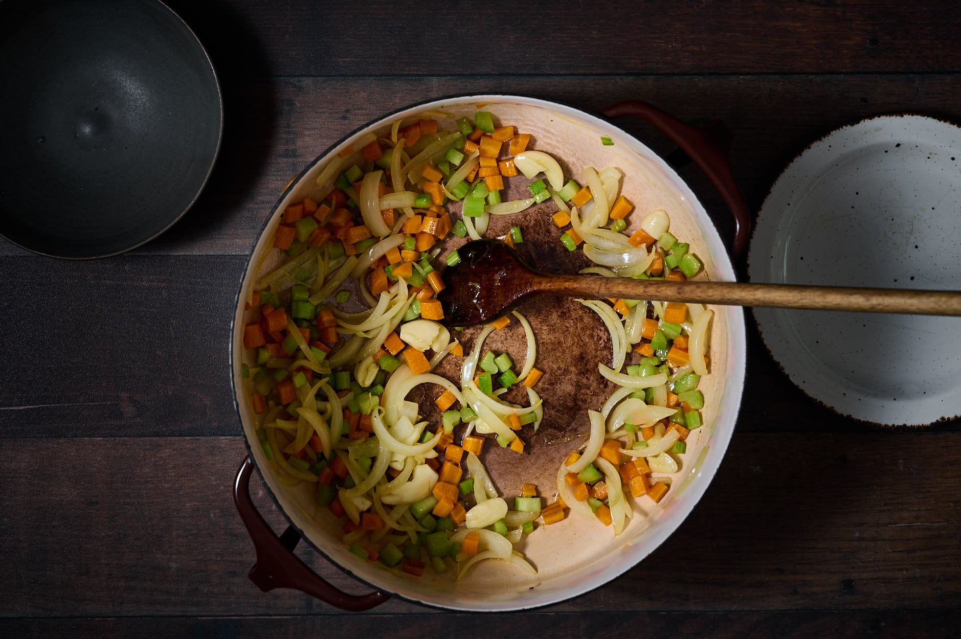 Pollo alla cacciatora step 2 showing diced onion, carrots, and celery being cooked in a crockpot. 
