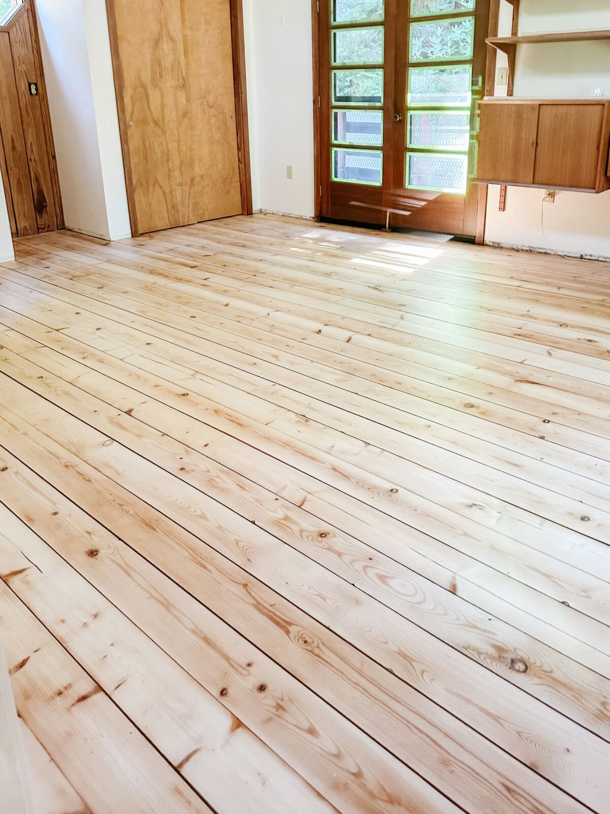 Cured hardwood pine floors with three coats of sealer dried and looking matte finish and honey white.