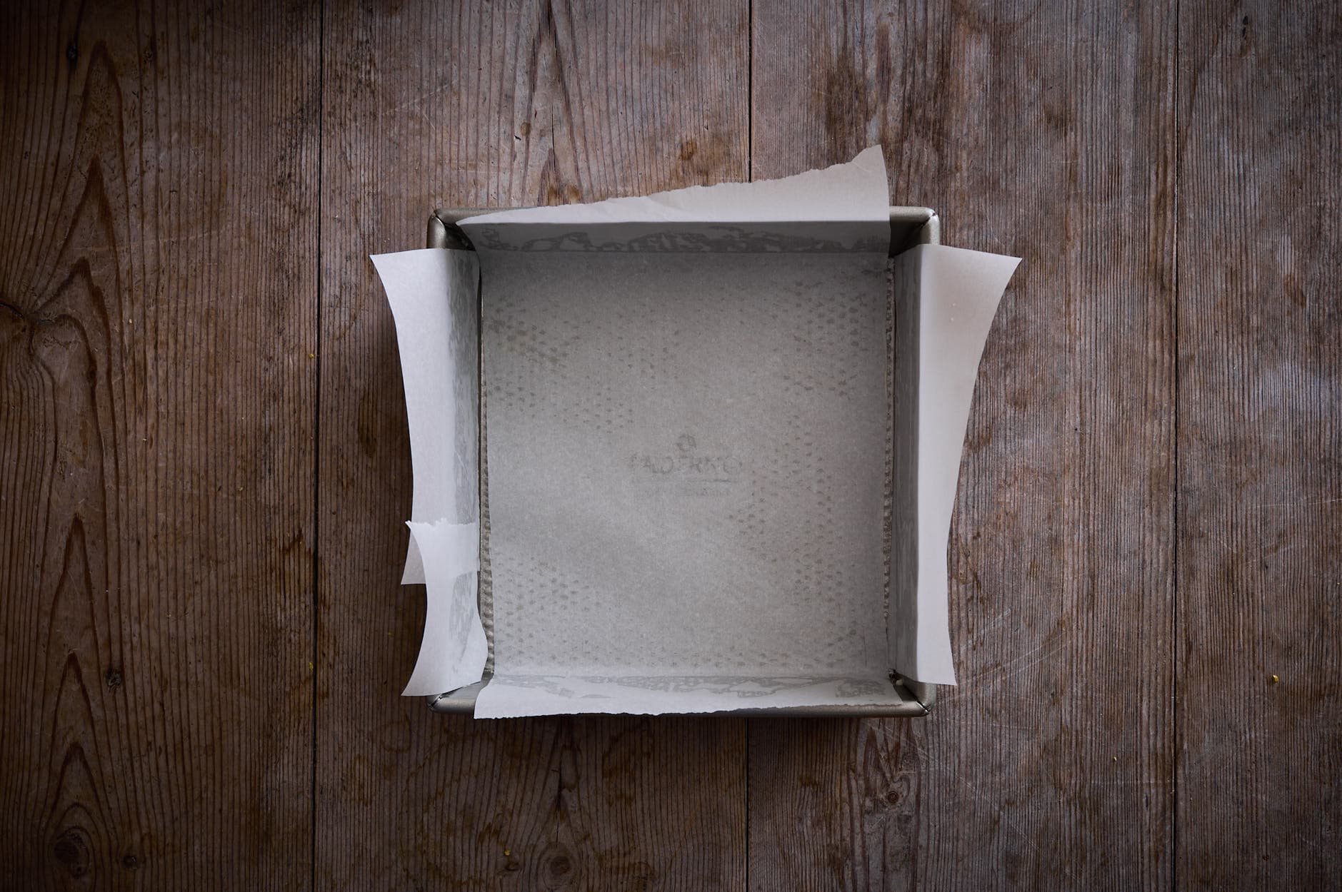 a prepared pan to bake lemon curd cake in a square tin with parchment paper. 