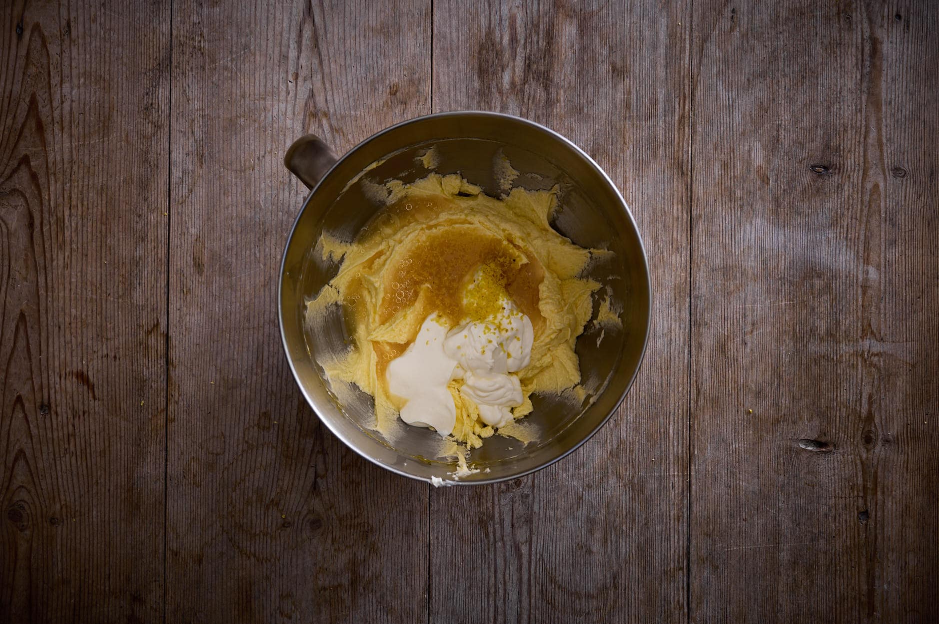 Lemon and poppy seed cake wet ingredients in a bowl that includes sour cream and cream cheese whipped.