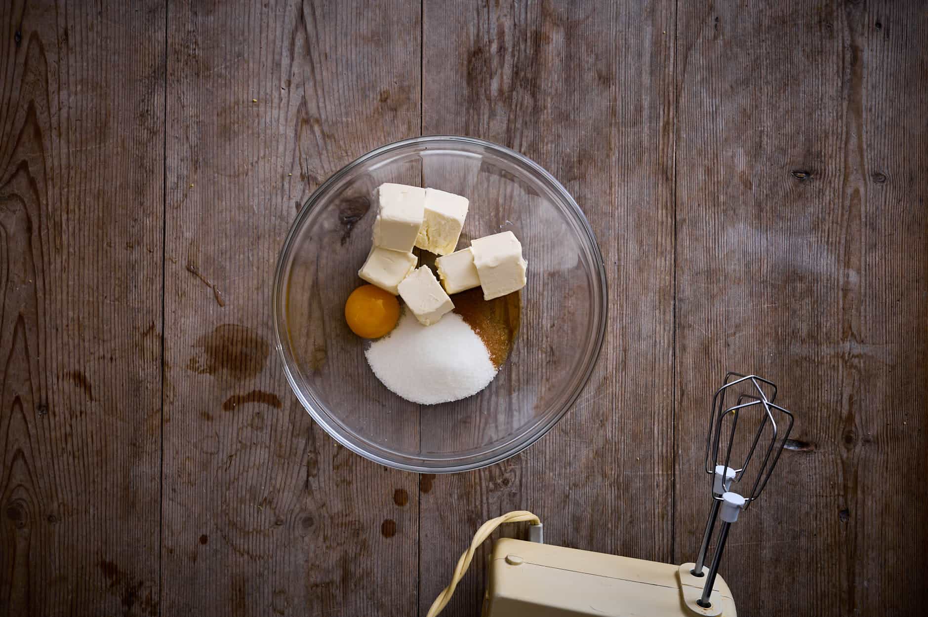 a bowl of the dry ingredients including sugar, egg yolk, butter etc and a beater. 