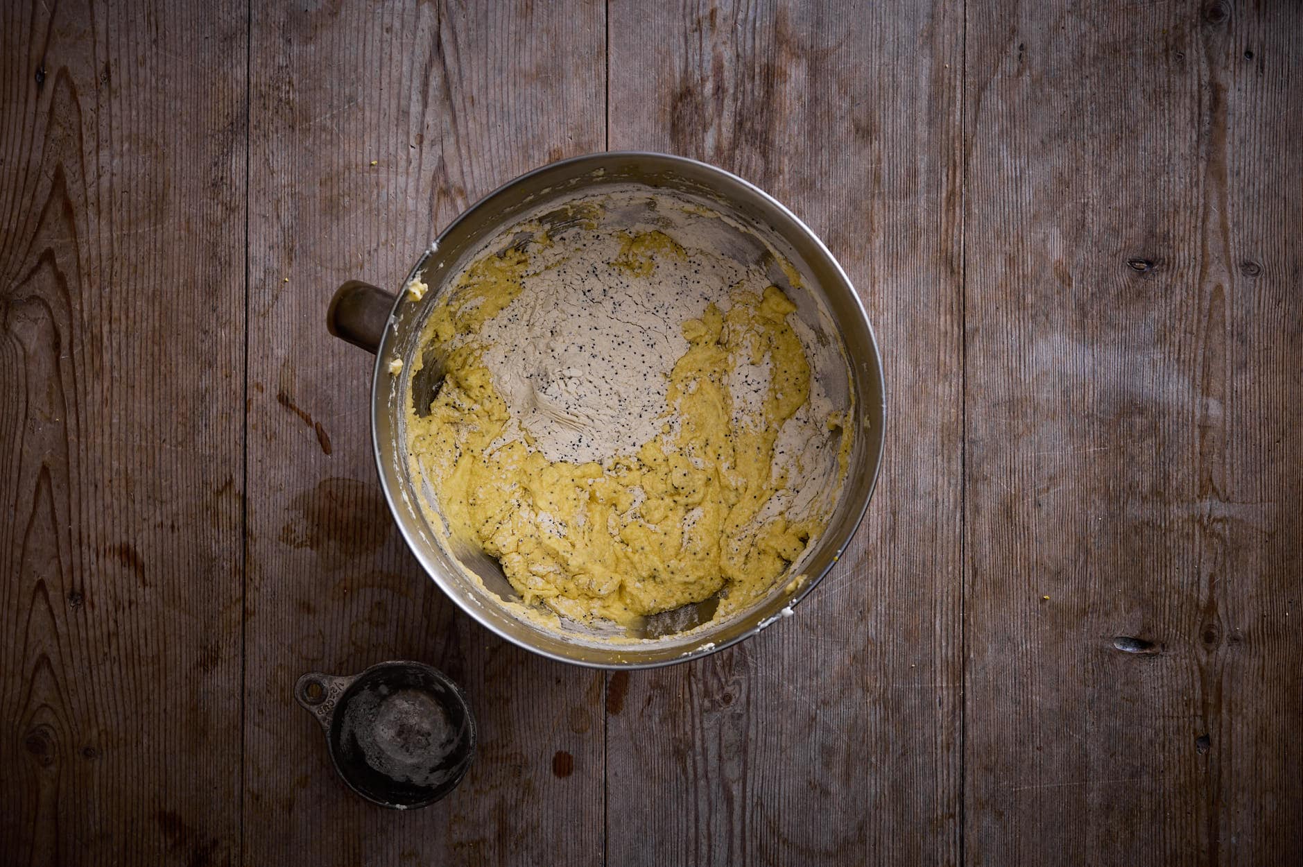 The batter mixed up and combine includes poppy seeds in a bowl. 