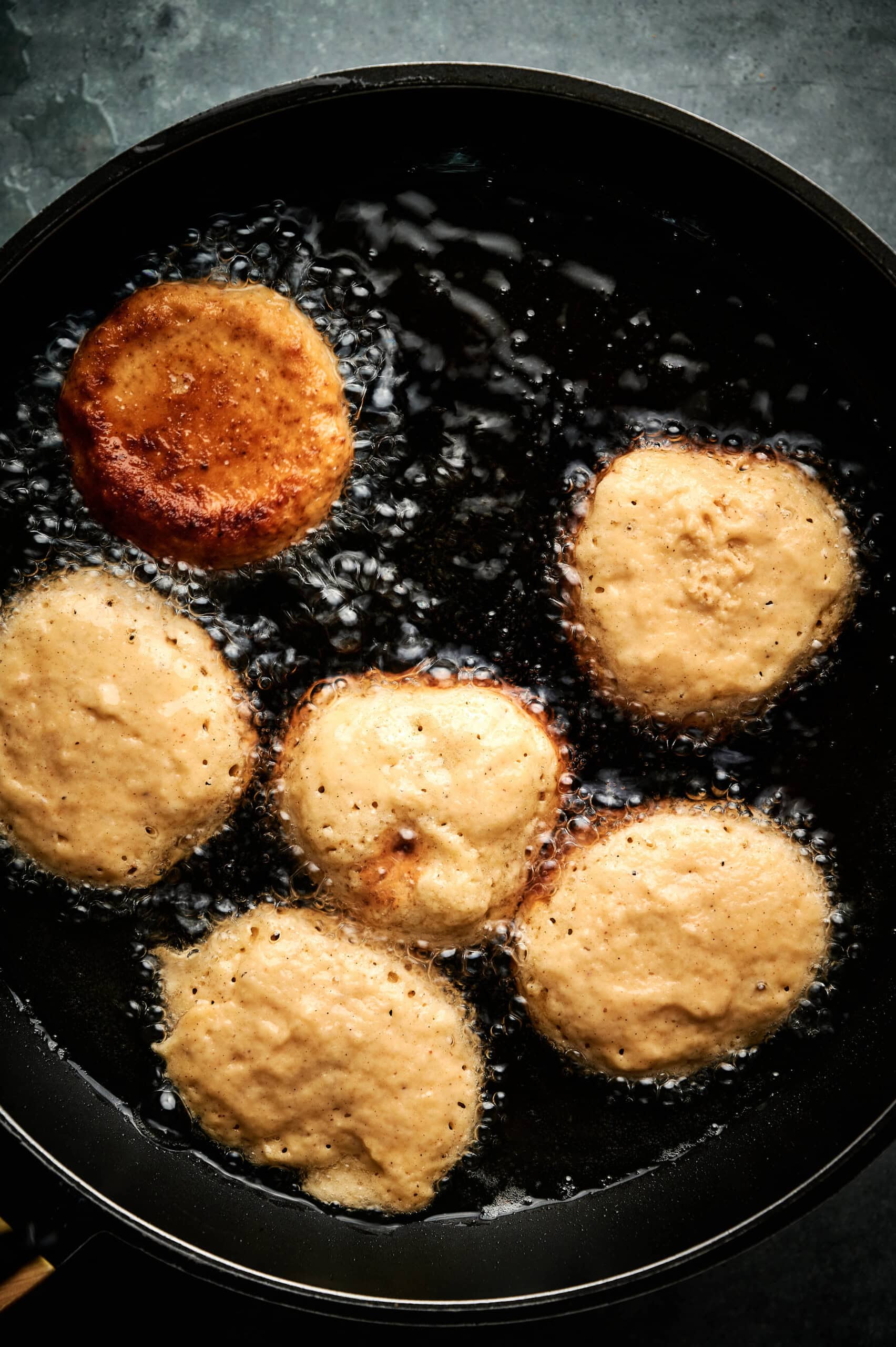 Fritters drying in peanut oil. 