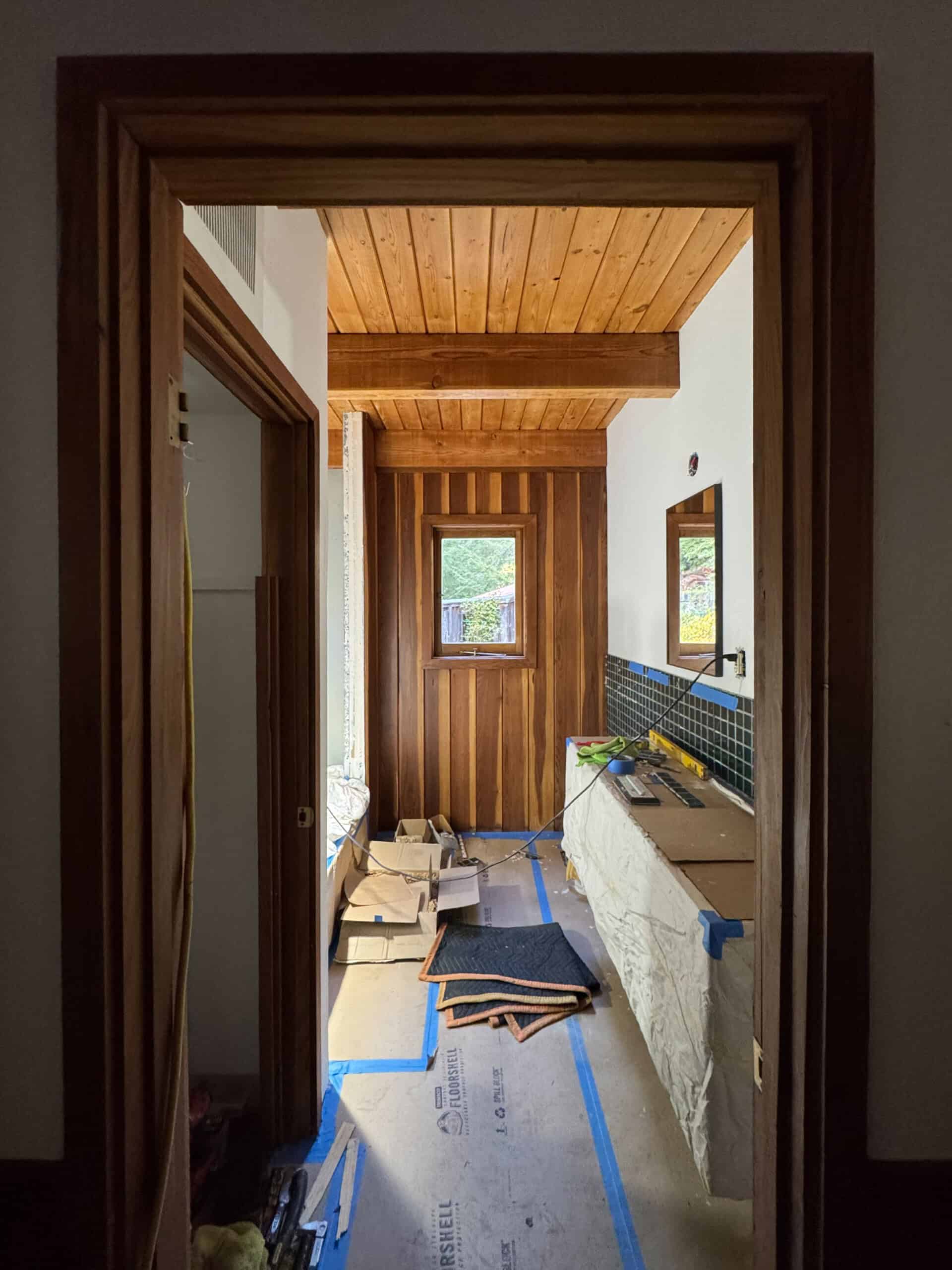 The cabin bathroom with the vanity installed and tile but covered on the floor with ramb board.