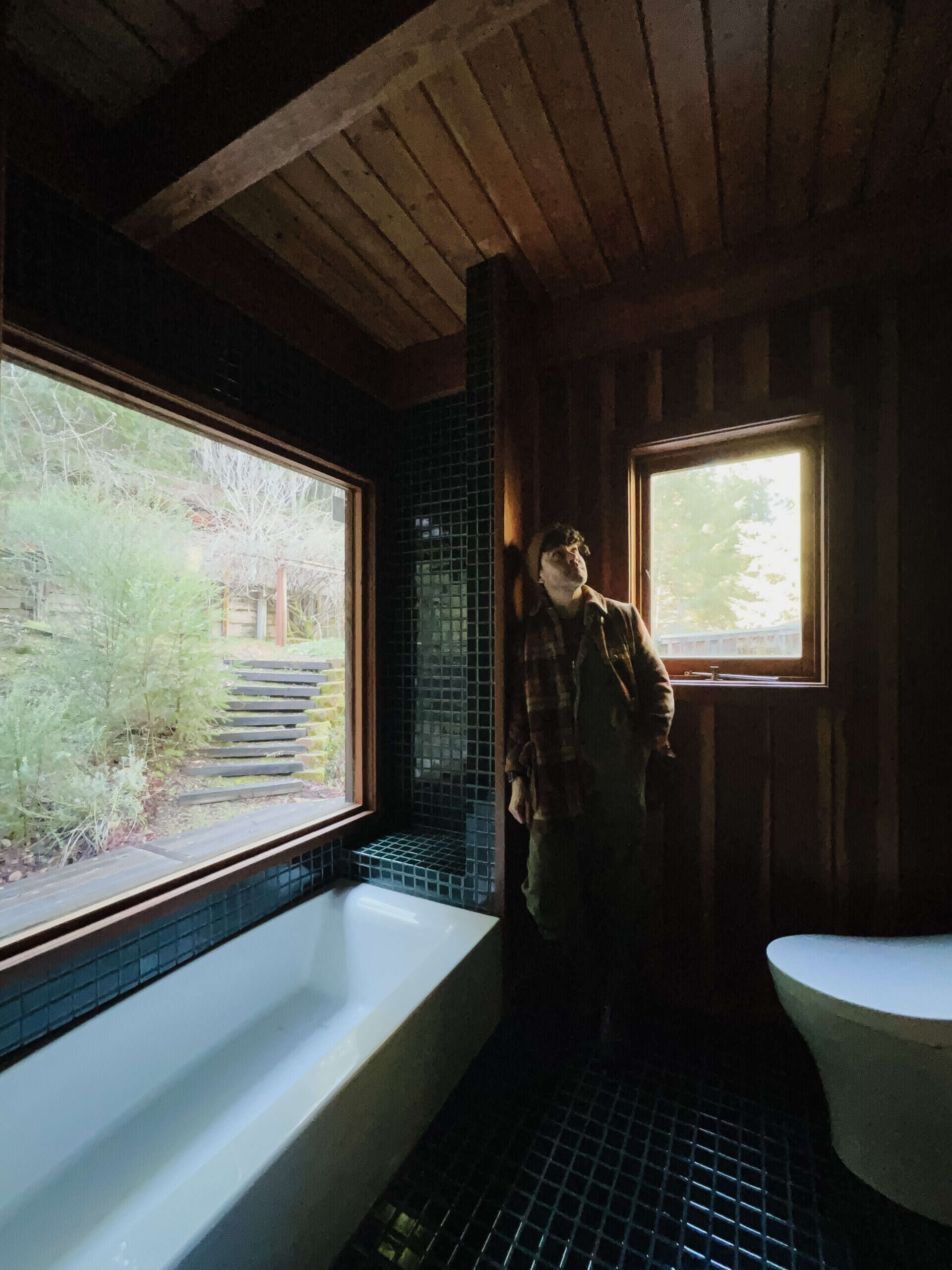 The moody bathroom featuring anthony in a flannel jacket. 