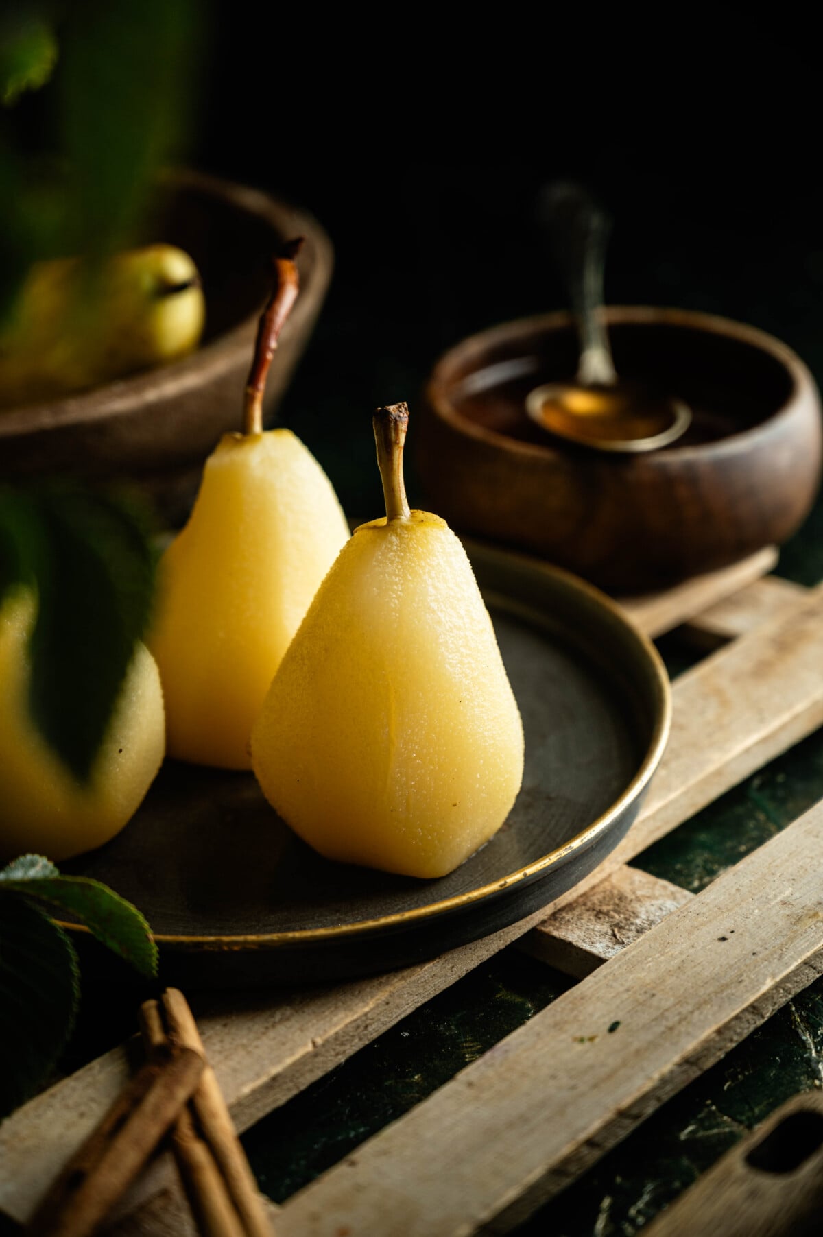 Easy poached pears recipe served with on a plate with a wooden table.
