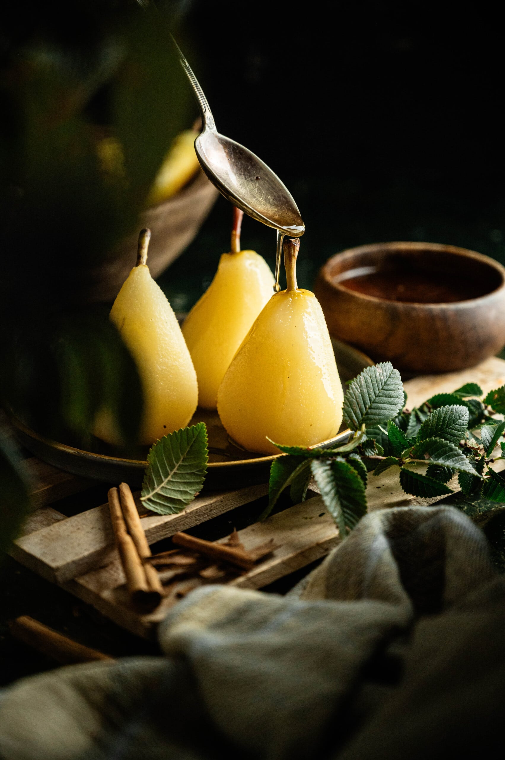 omemade poached pears dessert served in a bowl with reduced poaching syrup.