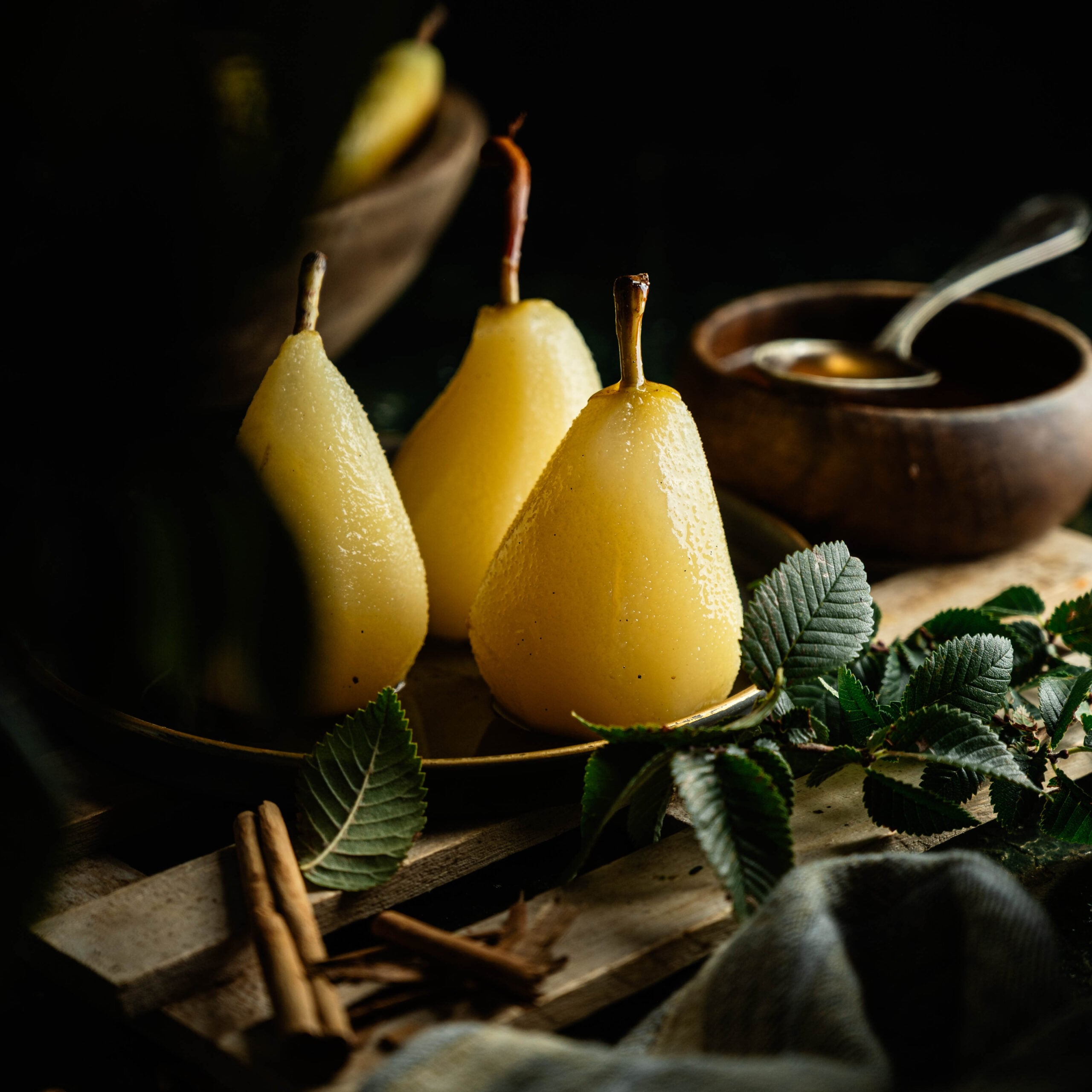 Homemade poached pears dessert served in a bowl with reduced poaching syrup.